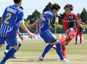 【ホンダロック-横河武蔵野】後半３分、相手選手の間を抜くシュートで２ゴール目を決めるFW米良（右）＝小林総合運動公園市営陸上競技場