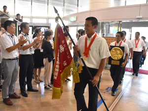 【写真】市職員に拍手で迎えられ、笑顔で庁舎に入る日南学園高野球部の選手たち＝２５日午後、日南市役所